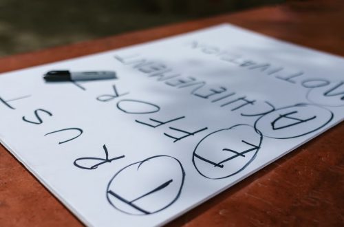 A paper with motivational words and markings placed outdoors on a table.